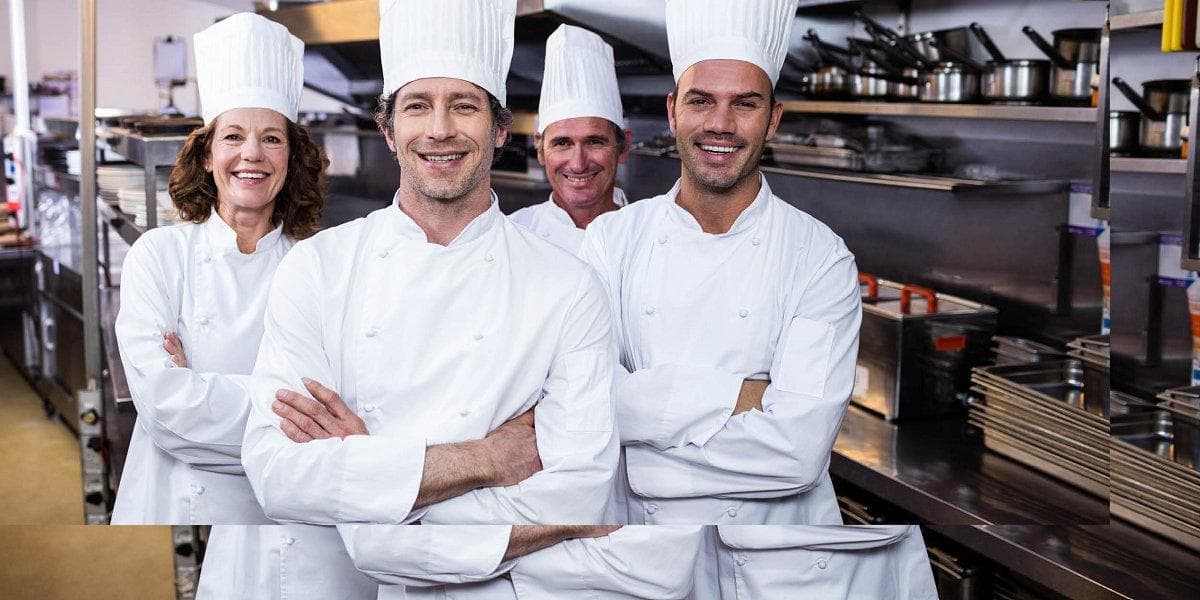 Kitchen team wearing professional chef uniforms
